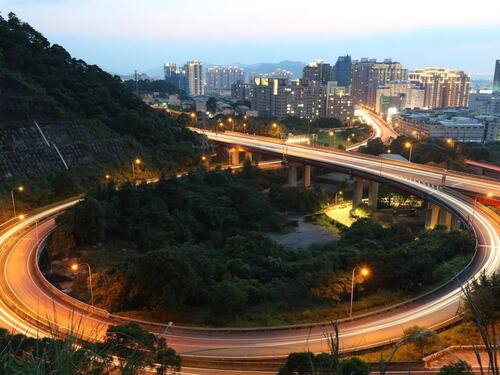 City Lights and Curved Highway at Dusk