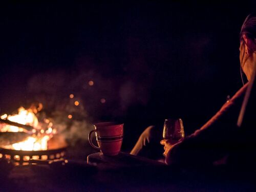 Relaxing by a Fire Pit with Drinks at Night