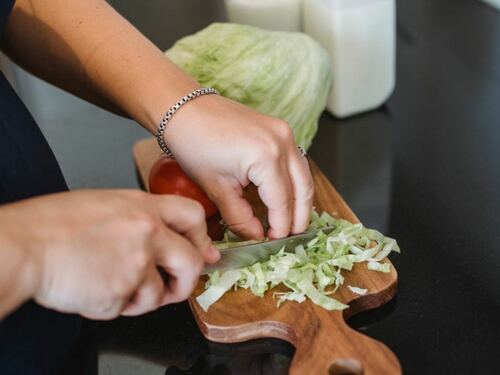 Chopping Fresh Lettuce on Wooden Cutting Board