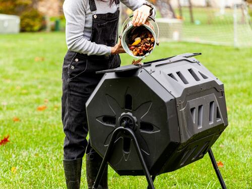 Person Using a Compost Tumbler in the Backyard