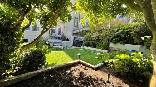 Lush Urban Backyard with Mature Trees and Lawn