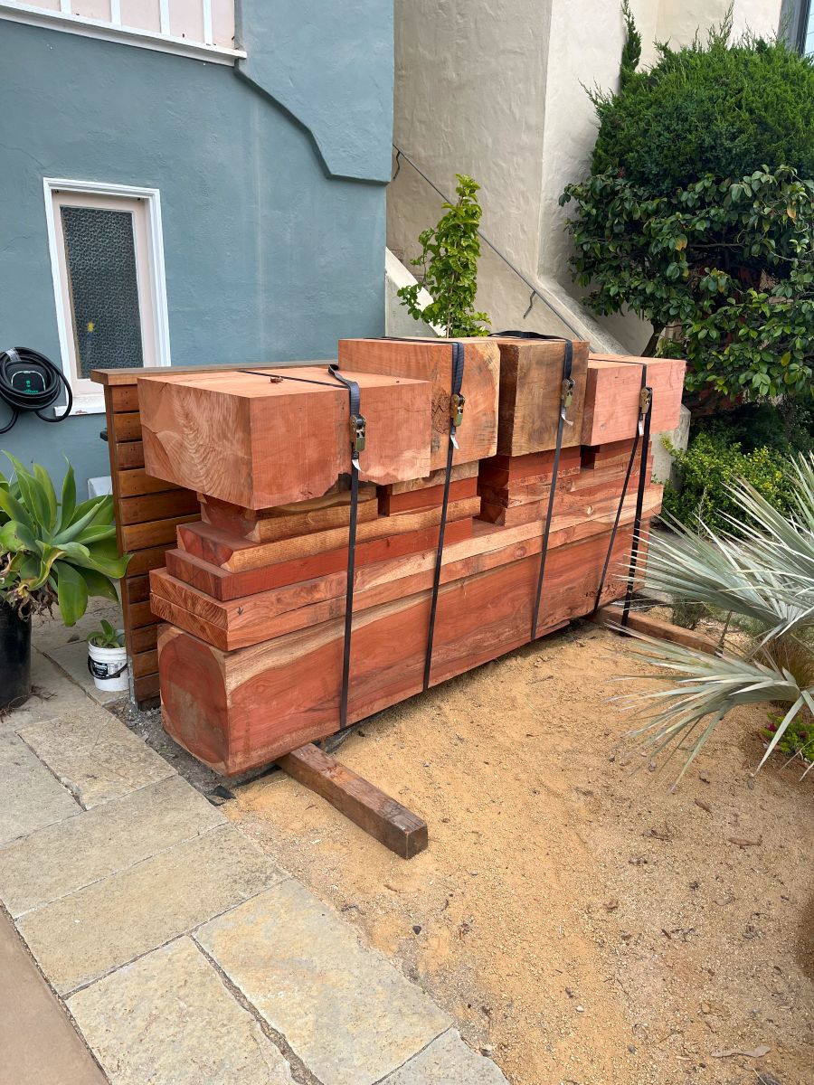 Custom milled residential urban wood lumber stacked on-site in San Francisco, showcasing locally salvaged Bay Area trees transformed into usable beams and slabs.